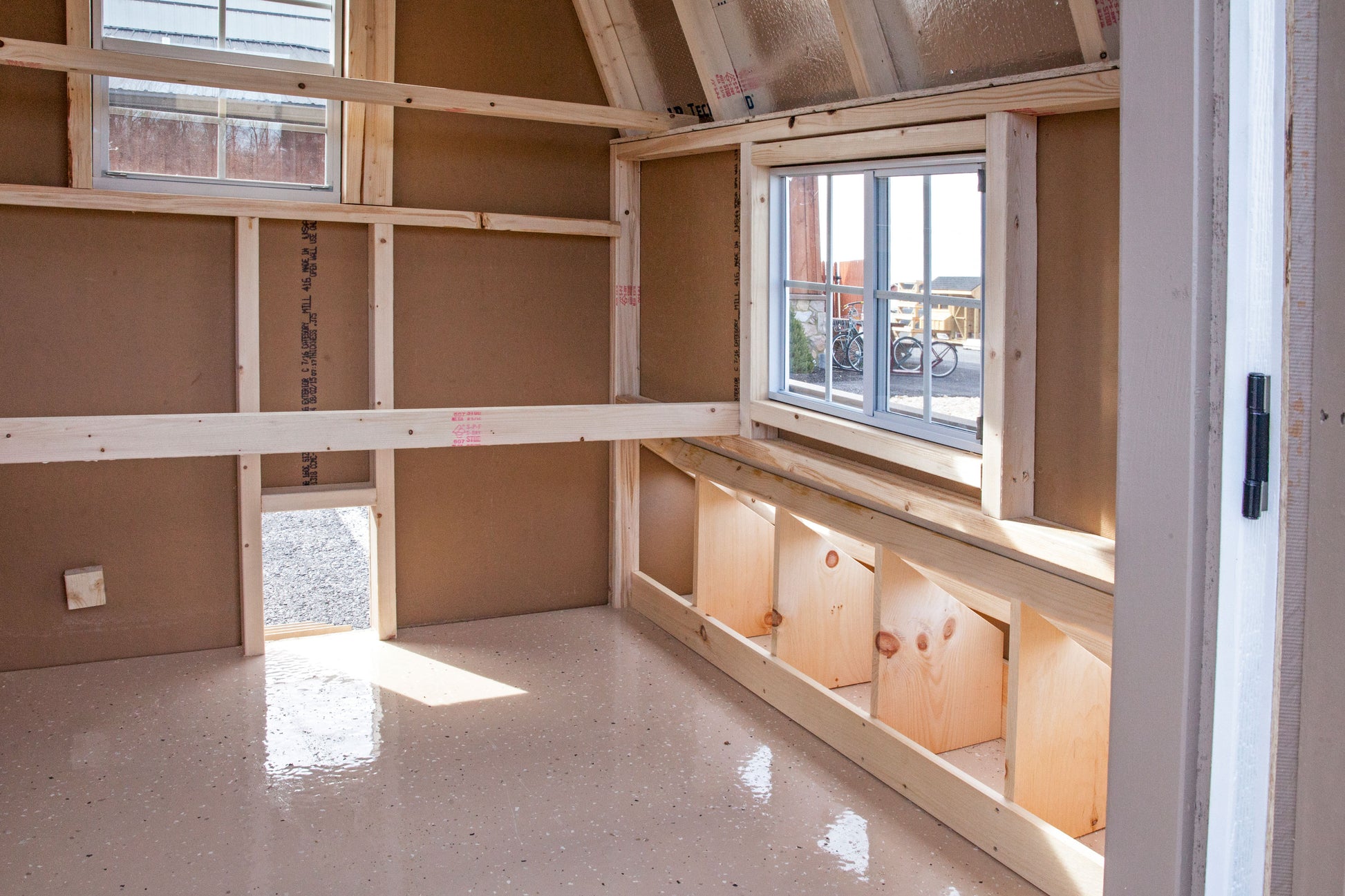 Side interior view of a 4x4 chicken coop showing a secondary window for cross-ventilation and a grey epoxy floor.