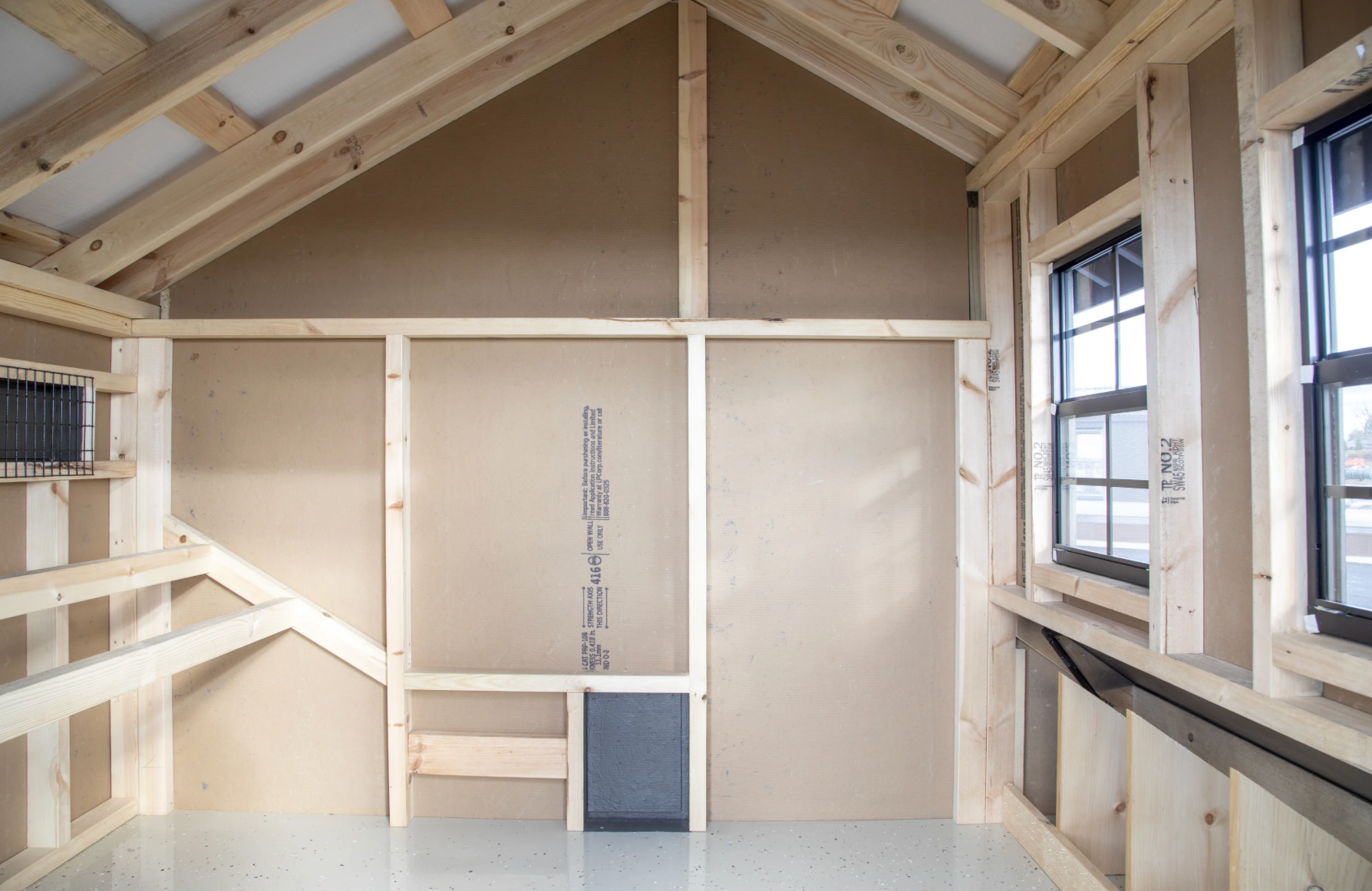 Interior view of 7x6 chicken coop area with roosting bars, nesting boxes, windows, and clean wood construction.