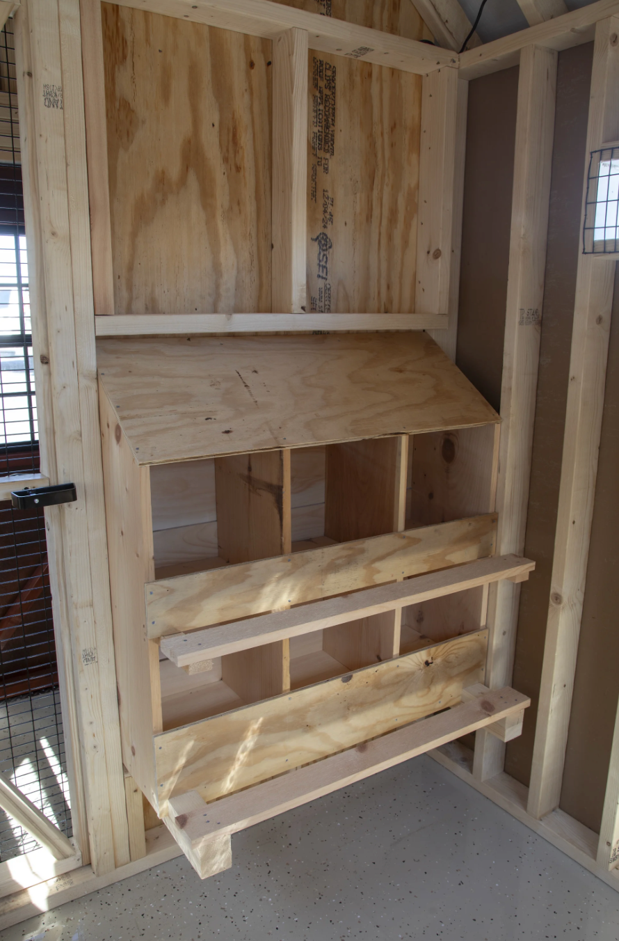 Interior view of A610TF 6x10 A-frame chicken coop showing wooden nesting boxes and enclosed feed room