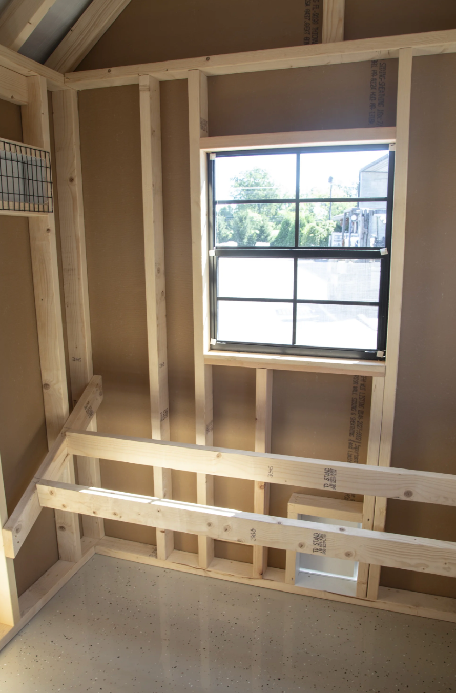 Interior of A610TF A-frame chicken coop with roosting bars and natural light through window