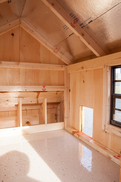 Interior of Amish-built chicken coop showing epoxy-coated floor and screened windows