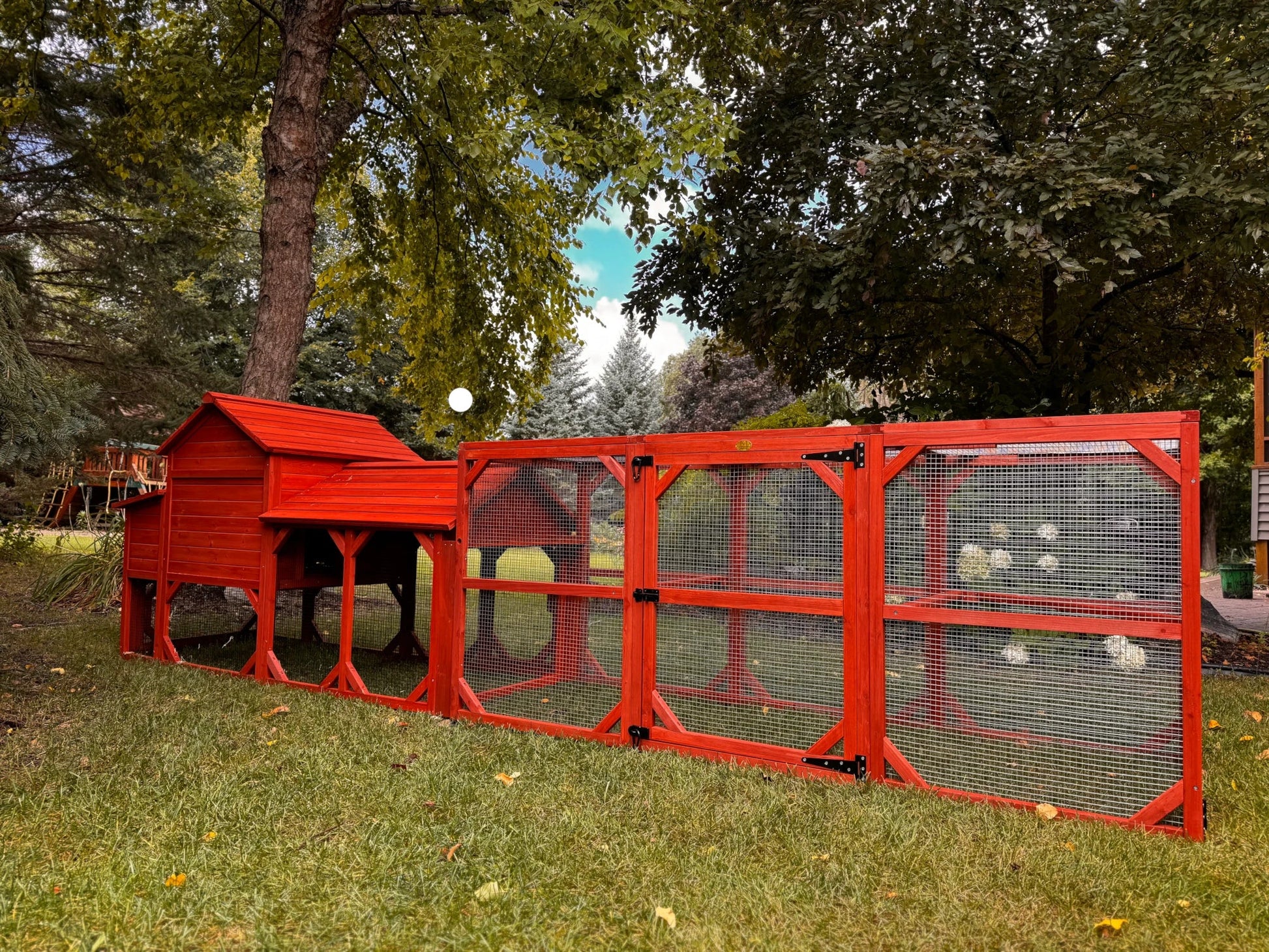 Side angle view of Leghorn Cottage chicken coop showing full run length, hen house elevation, and complete kit assembly in outdoor setting