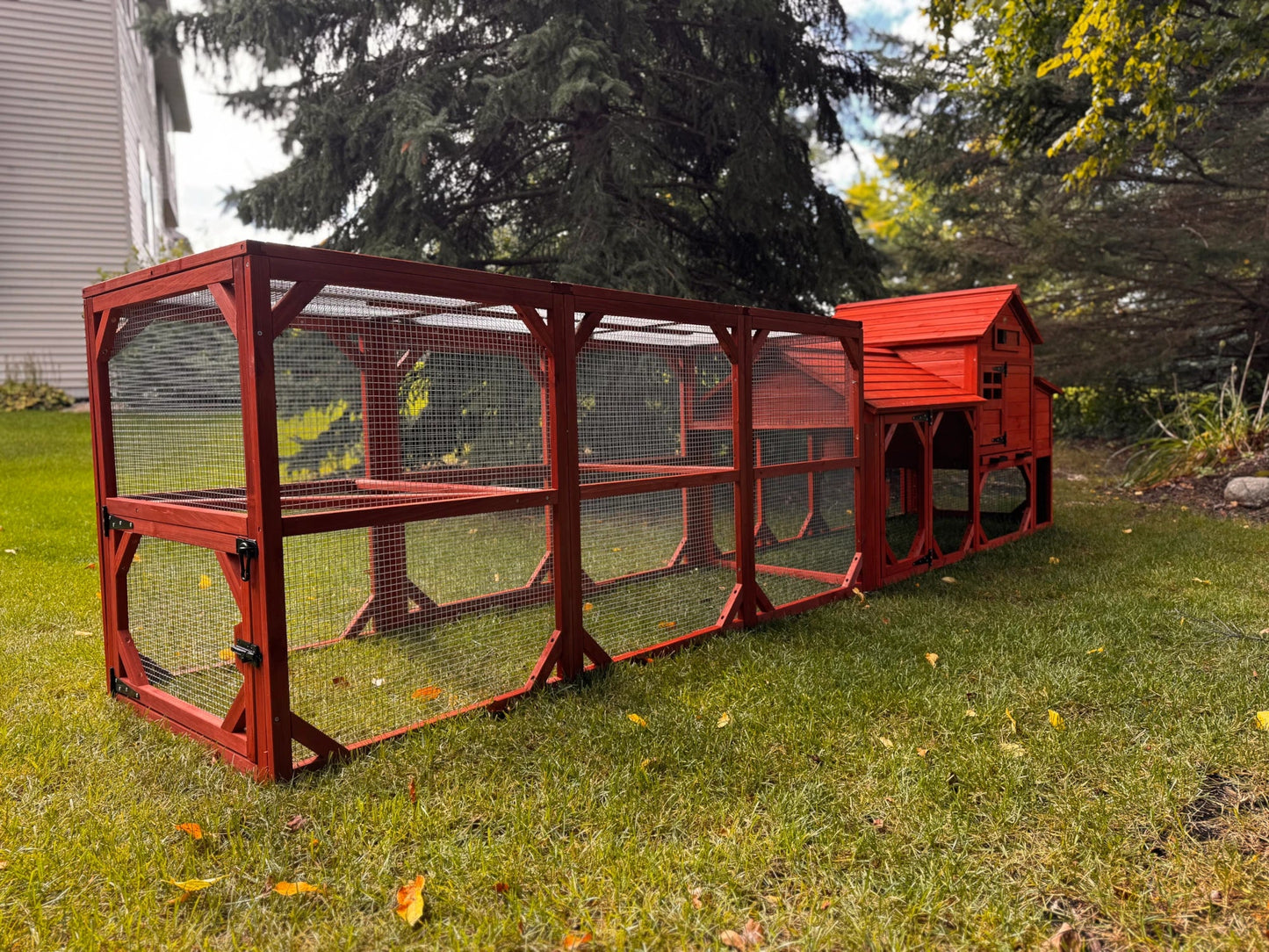 Side view of Leghorn Cottage chicken coop run extension showing wire mesh construction, wooden frame panels, and underrun clearance beneath nesting box