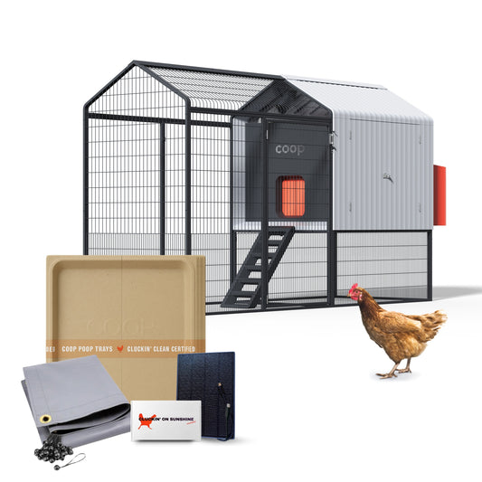 The Smart Coop Unlimited Edition bundle featuring a modern automated coop with attached steel run, shown with the included Cluckin' on Sunshine solar panel kit, grey all-weather tarp, and compostable waste trays.
