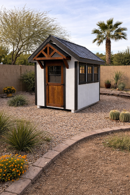 Modern white and black chicken coop with wood door placed in an Arizona backyard with desert landscaping and gravel.