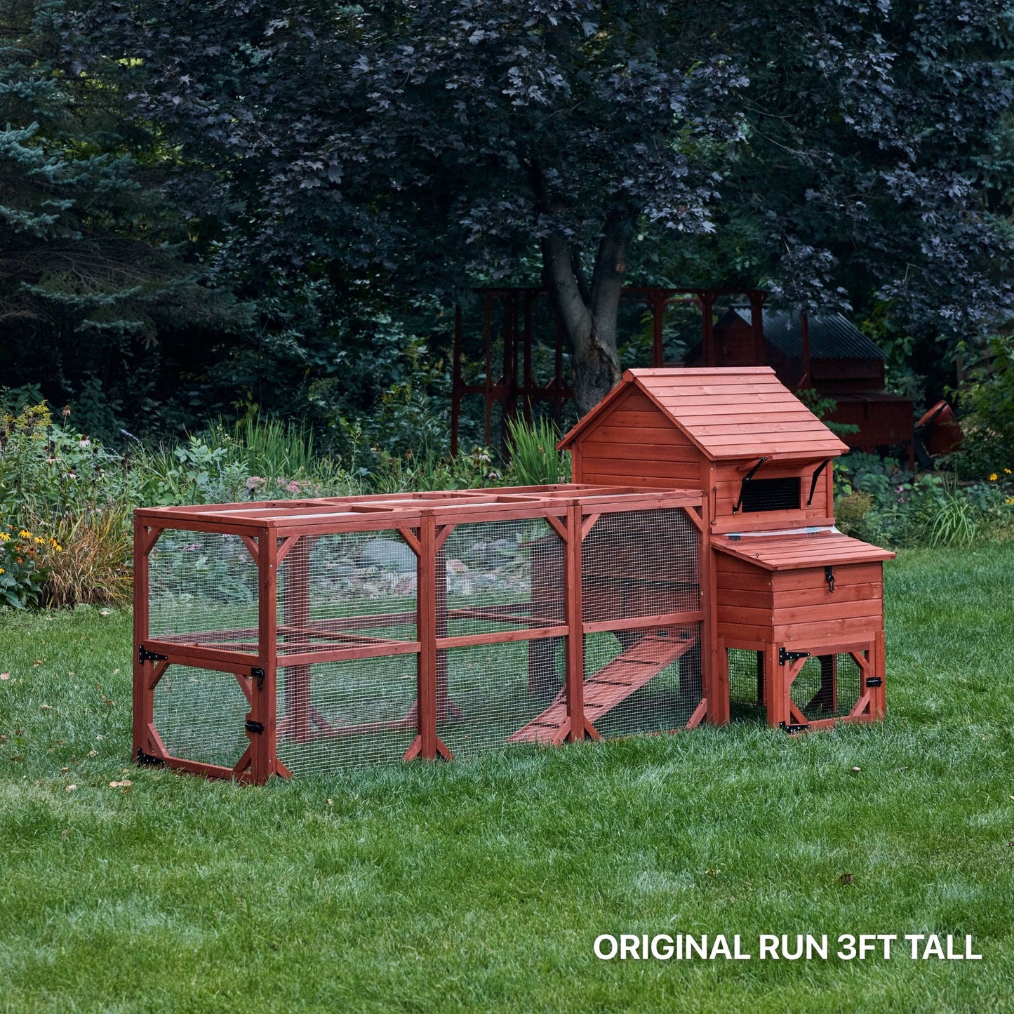 Orpington Lodge chicken coop kit assembled in a wooded backyard setting showing real-world placement with full hen house and run extension