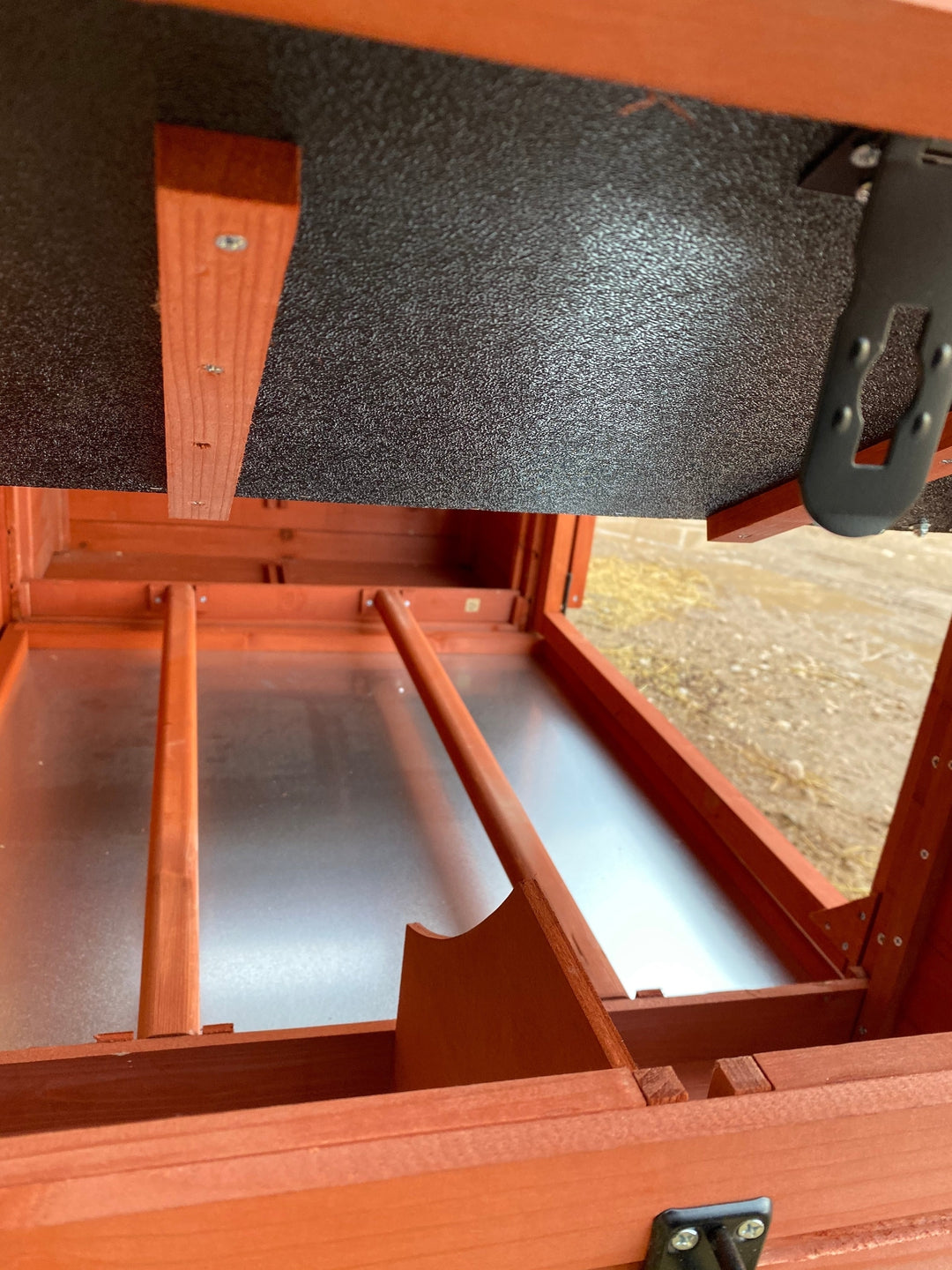 Close-up of Orpington Lodge chicken coop sliding pull-out waste tray showing easy cleaning system beneath the hen house floor