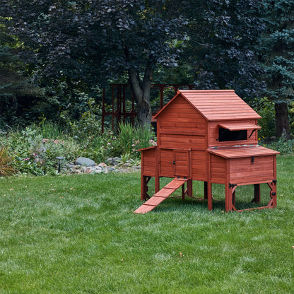 Wooden chicken coop on a grassy area with trees in the background